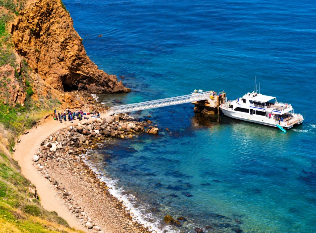 Sunny Rocky Cove with Tour Boat Pier