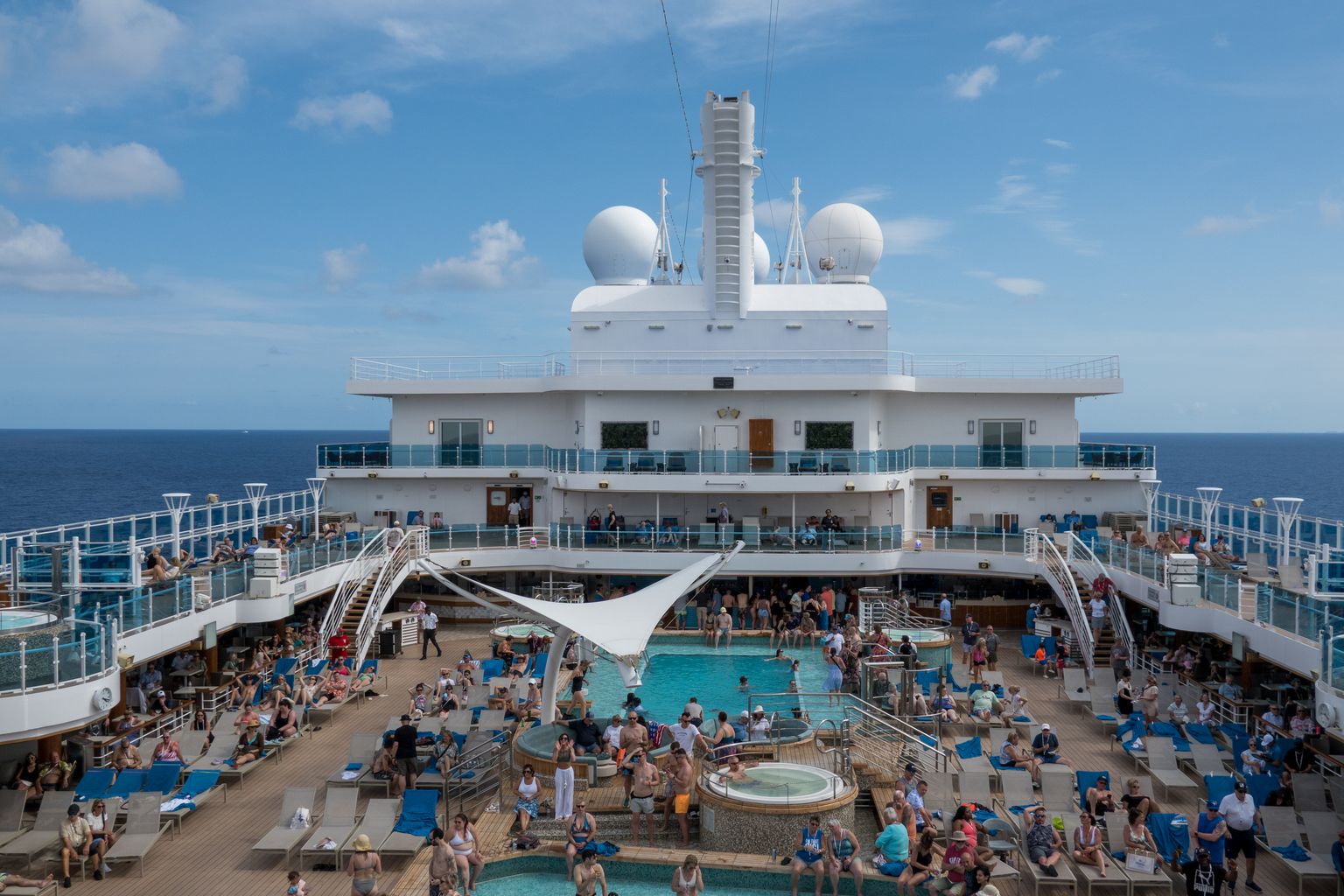 Passengers by the pool on a cruise ship sea day, when a drink package calculator shows the most value