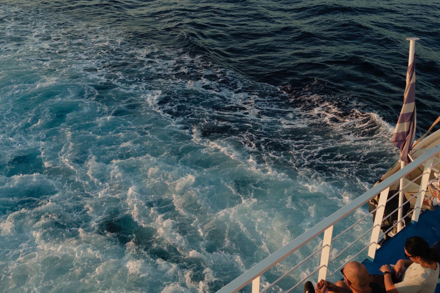 passengers on deck of a ferry from Athens to Santorini at sunset